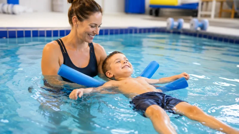 A kid doing hydrotherapy exercise in the pool