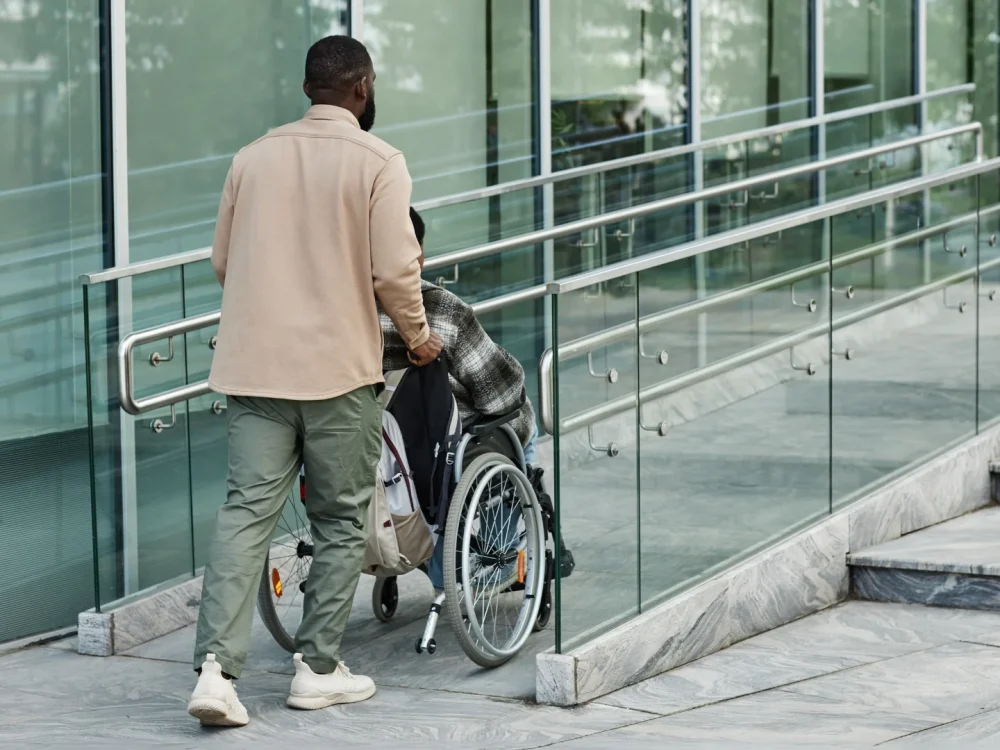 A man pushing a wheelchair showing the need of a physiotherapy for stroke recovery