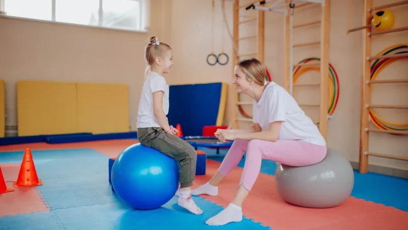A kid sitting in a ball